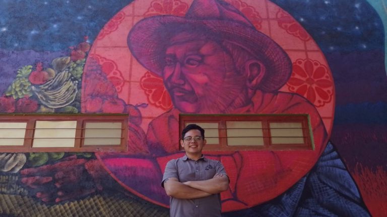 Zacatelco: Artista pinta en la escuela Simón Bolivar mural sobre migración